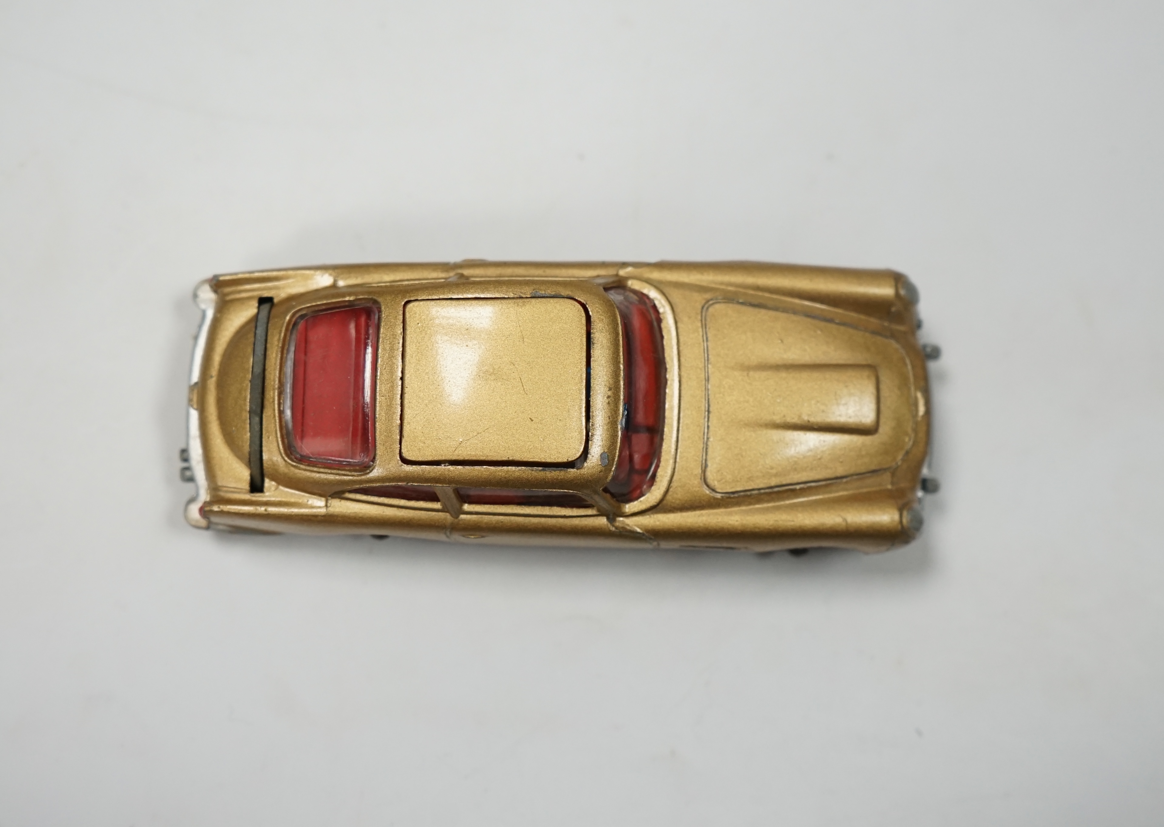 A Corgi Toys (261) James Bond 007 Aston Martin in gold, together with its original box, card display stand, secret instructions and envelope, and an additional spare passenger. Condition fair to good, minor chips to the